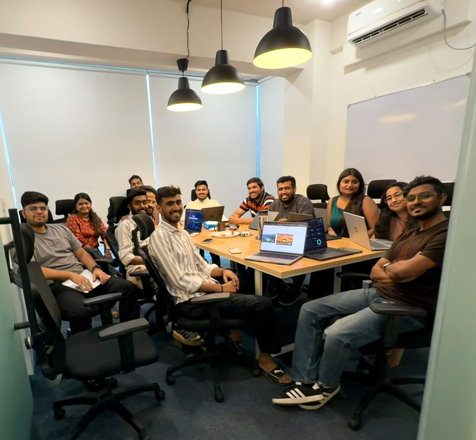 Trivas team huddled around a meeting room table, shot two