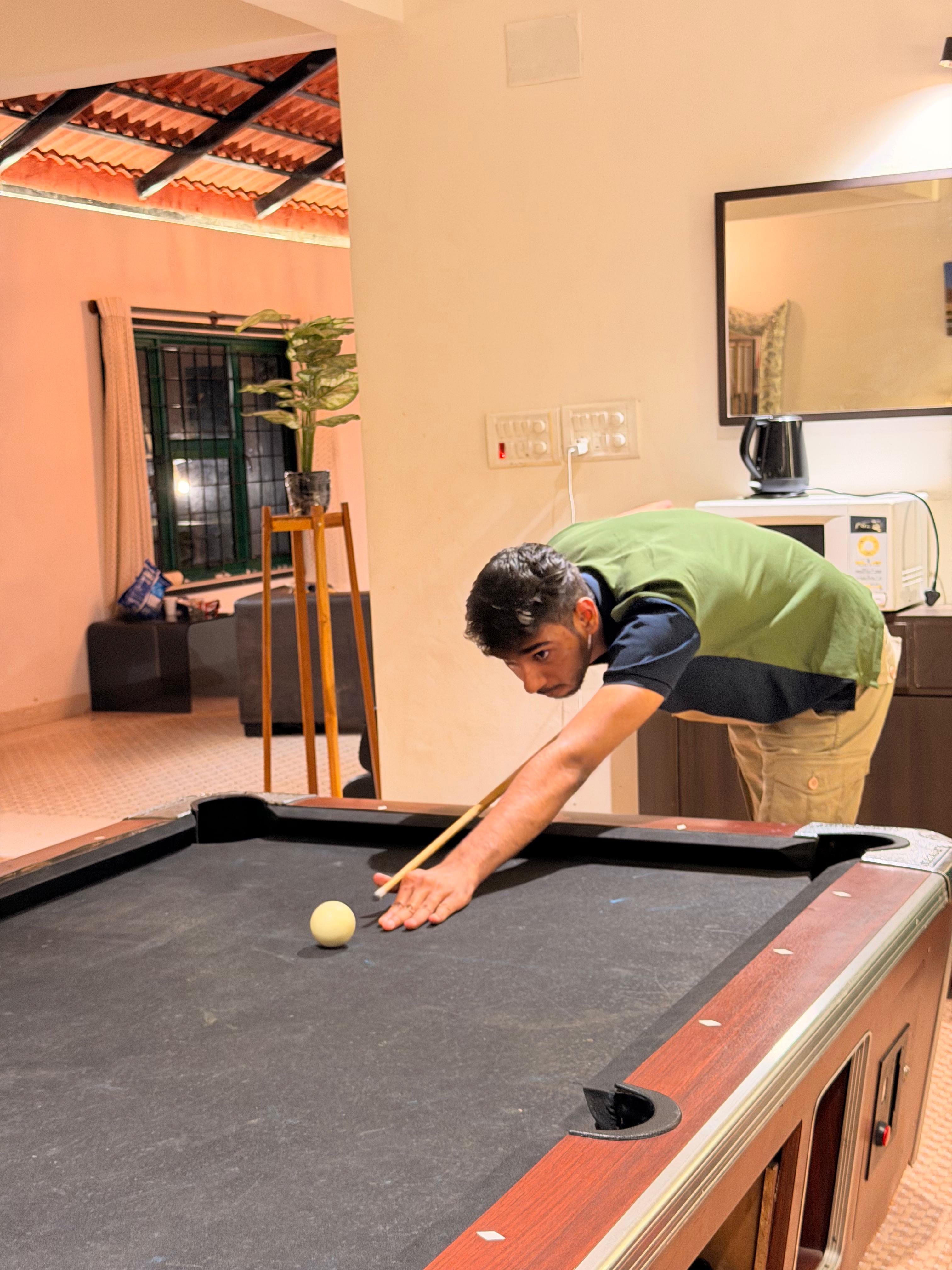 Trivas teammate lining up a pool shot