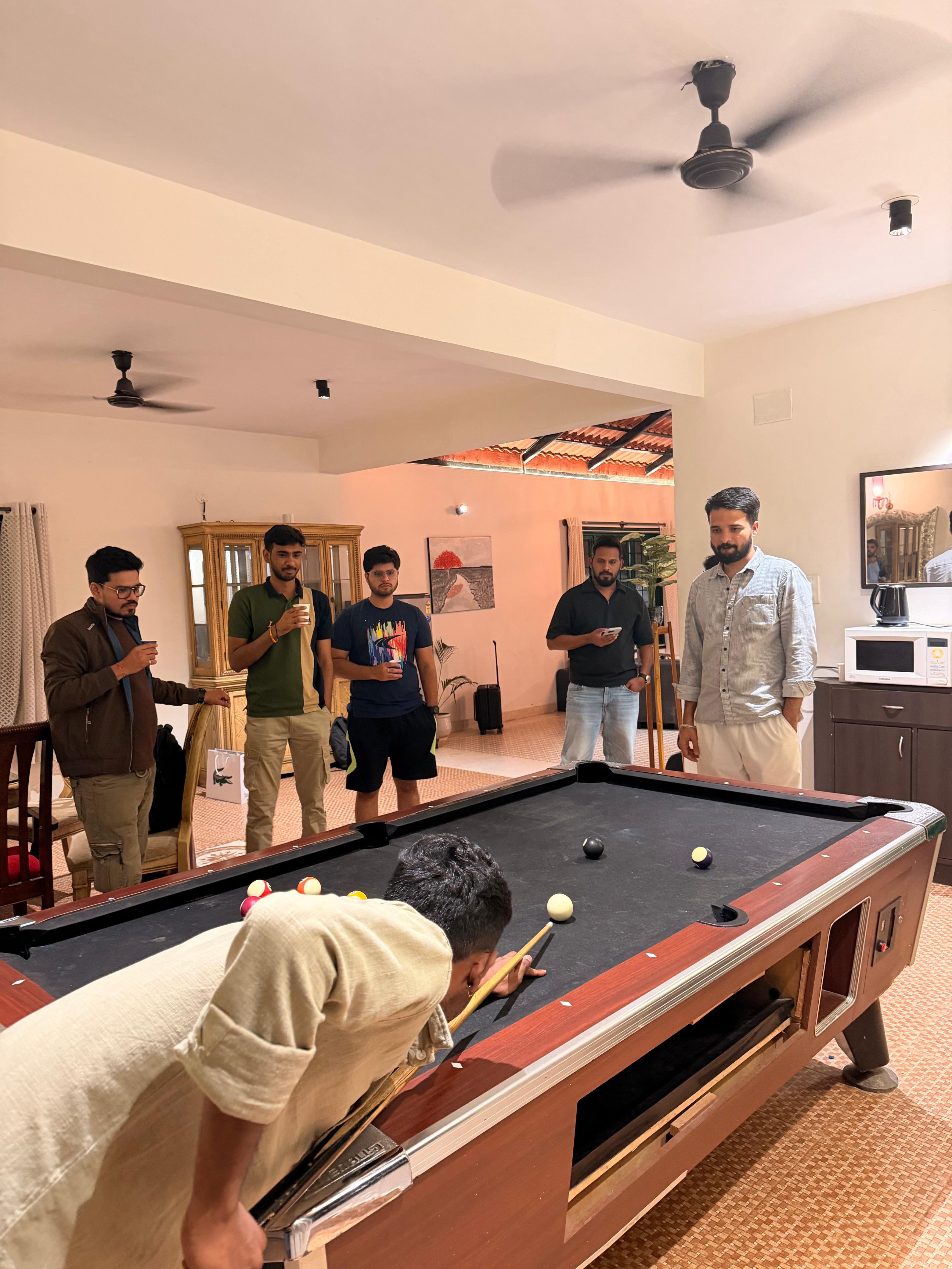Trivas team watching a game of pool